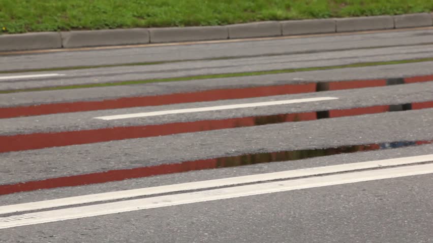 Man naked legs run in jogging shoes on asphalt with puddles
