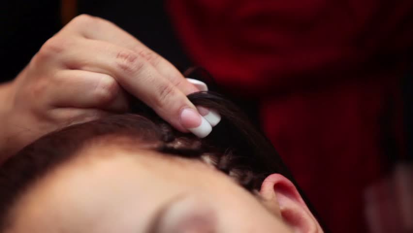 Process of braiding by hands, no faces are visible