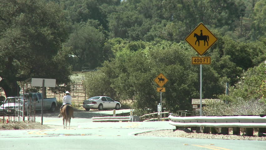 Horse rider next to a horse crossing sign at the Ventura River Preserve in Ojai, California.