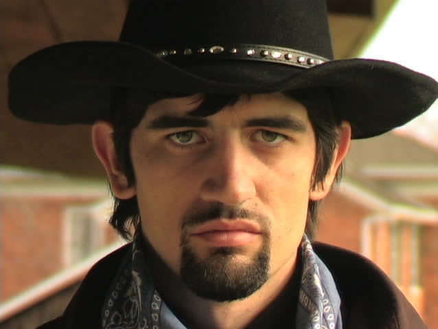 CLOSE-UP OF A COWBOY PUTTING A TOOTHPICK IN HIS MOUTH.