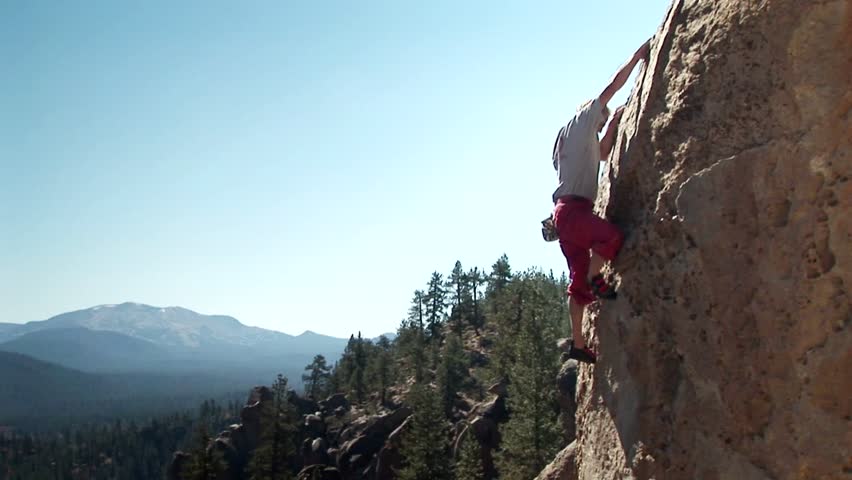 JOSHUA TREE, CA - CIRCA 2009: A man climbs up the side of a mountain circa 2009 in Joshua Tree.