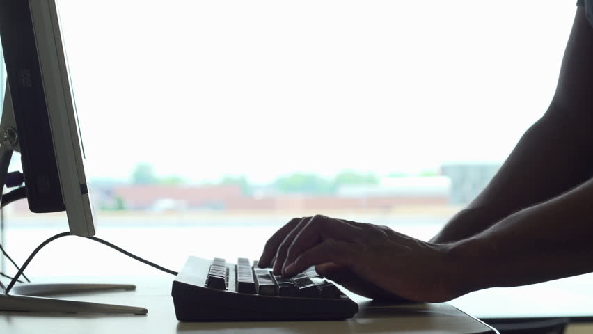 Man at computer terminal typing