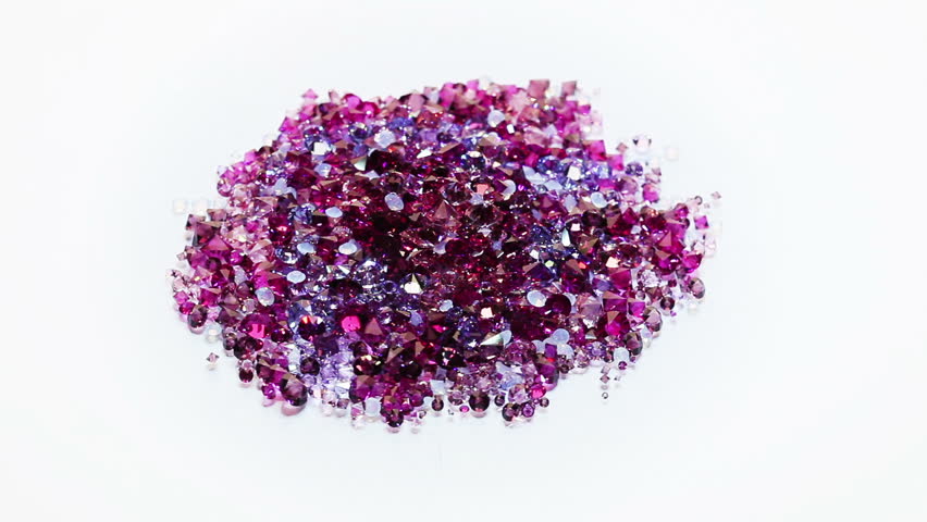 Jewel stones heap in violet tones spinning over white background