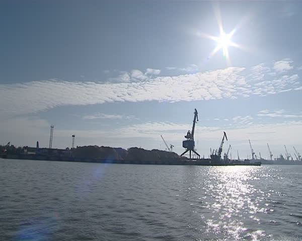 Cranes at the port shot from ships passing by. Nautical cargo industry. 