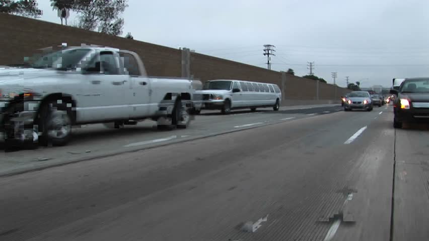 A stretch limo drives down a freeway