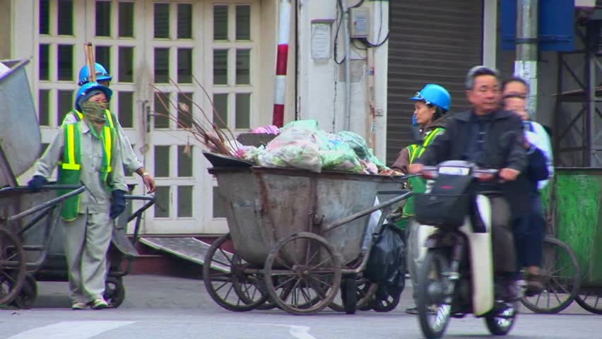 HANOI, VIETNAM - CIRCA 2010: Garbage collectors clean up the streets in Vietnam.