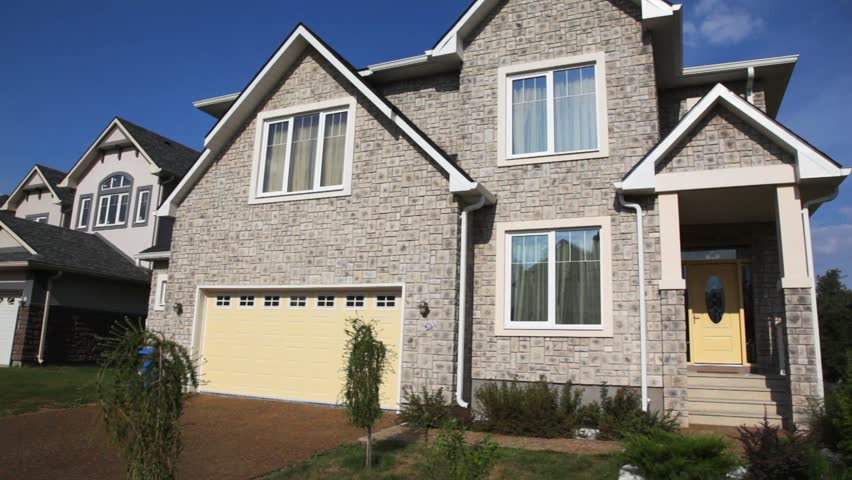 panorama of gray brick house and other houses in street