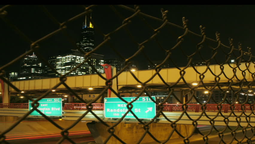 Traffic passes under a freeway overpass at night