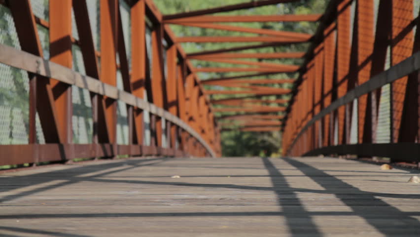 A runner jogs on a bridge on a beautiful autumn day.