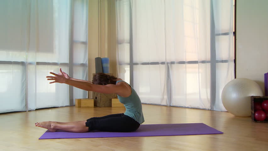 Young woman performing pilate move on a mat