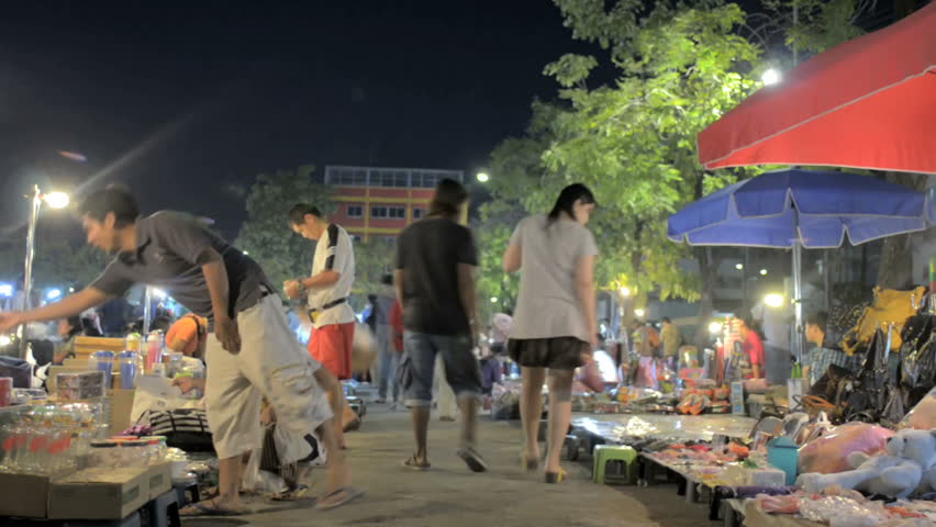 BANGKOK, THAILAND - NOVEMBER 2011: (Timelapse View) People browse and shop at a night market circa November 2011 in Bangkok, Thailand.