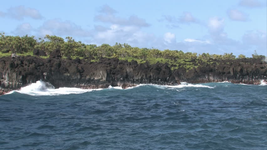 Rocky shoreline on the island of Maui in Hawaii.  Beautiful water. Waves splashing on rocks, scenic, relaxing and calm, beautiful tropical video. Jungle with palm on shore. Pacific ocean bay or cove.