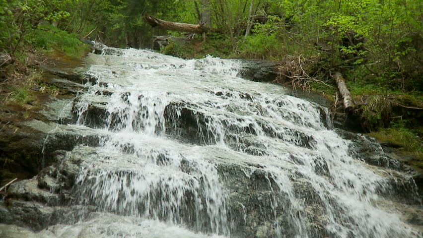 Water cascades down rocky steps in slow-motion