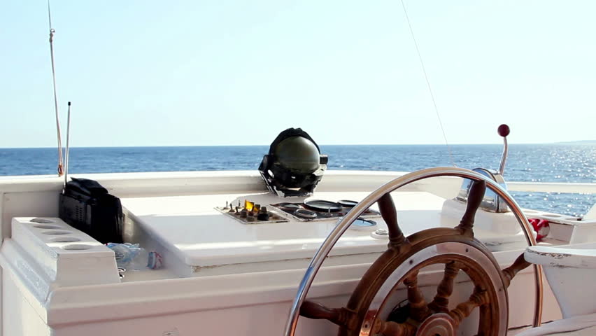 View from boat wheelhouse on a sea and blue sky.