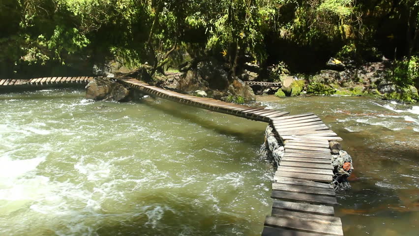Walking along a boardwalk over a river in the Ecuadorian Andes