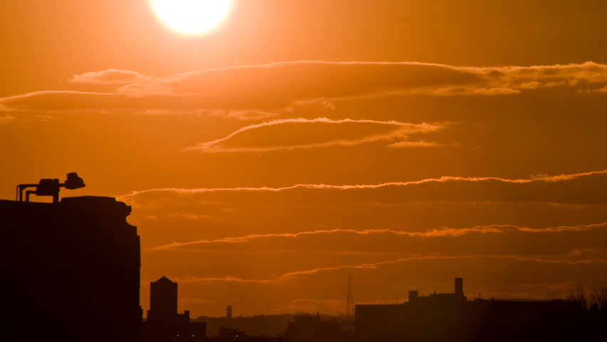 Timelapse of sunset over buildings 