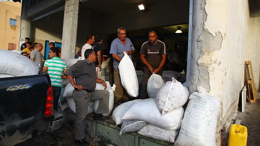 ISRAEL - NOV 6, 2010: Men stand outside olive oil factory with bags for shipment on November 6, 2010 in Israel.