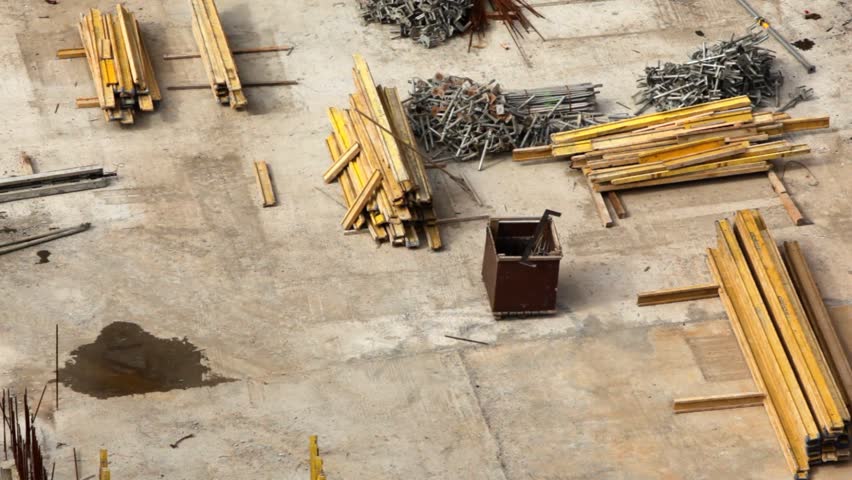 worker in orange overalls runs on building site among materials