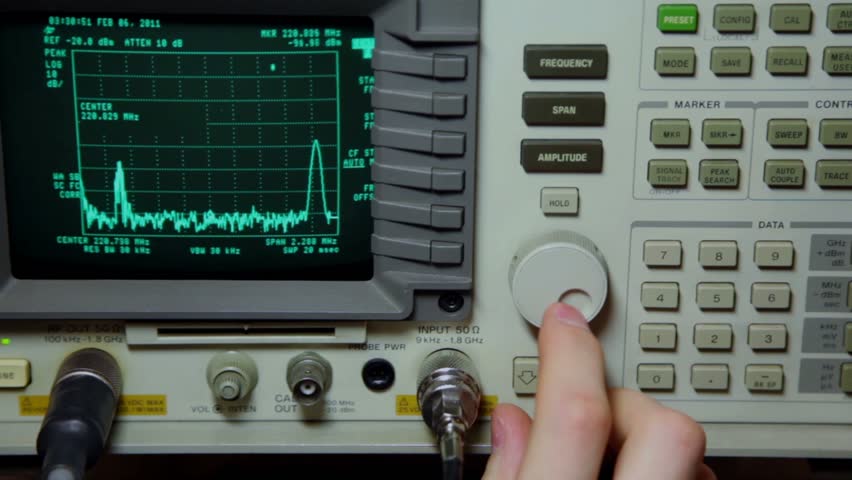 Hand push buttons and rotates knob on oscilloscope for old video repair