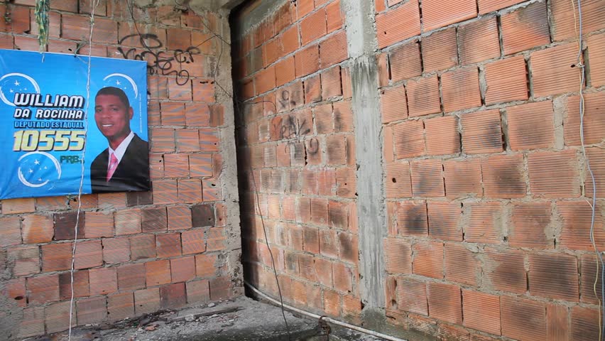 RIO DE JANEIRO, BRAZIL - CIRCA JUNE 2011: Bullet holes and graffiti surround an election poster on a favela wall circa June 2011 in Rio de Janeiro.