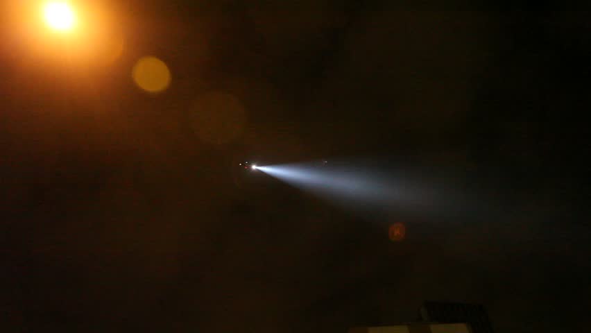 Military police helicopter shines searchlight down from night sky