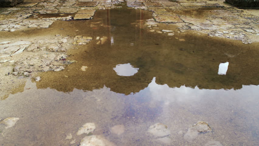 Tilt from a reflecting pool of water up to the walls just reflected in the pool of collected rainwater at the Bar'am synagogue in Israel .  02/20/2011