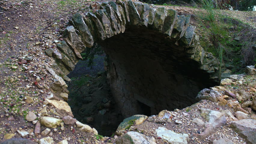A static shot of an archway looking down to an under ground area with an entry way and a very small window, in the ancient ruins of Bar'am, Israel. 02/20/2011