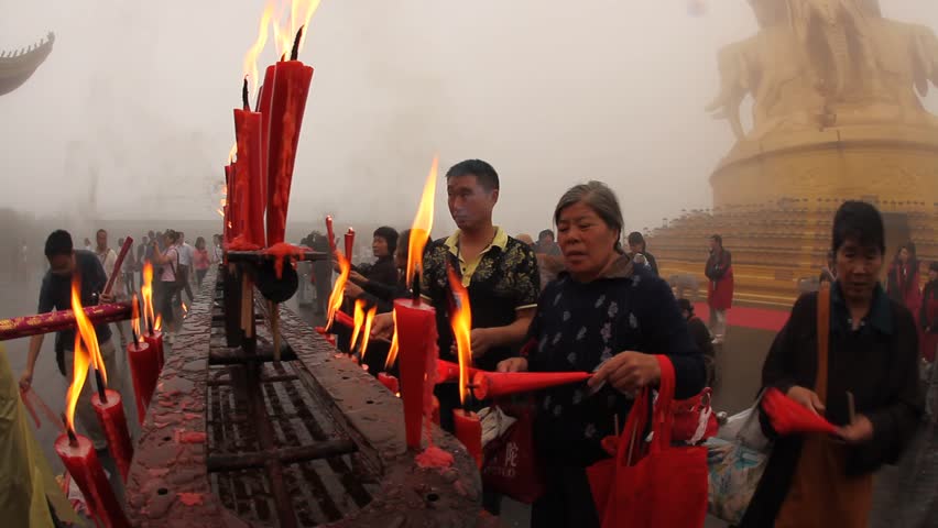 MOUNT EMEI, CHINA - JULY 22, 2009: People light candles and incense outside the Golden Summit Temple on July 22, 2009 on Mount Emei.