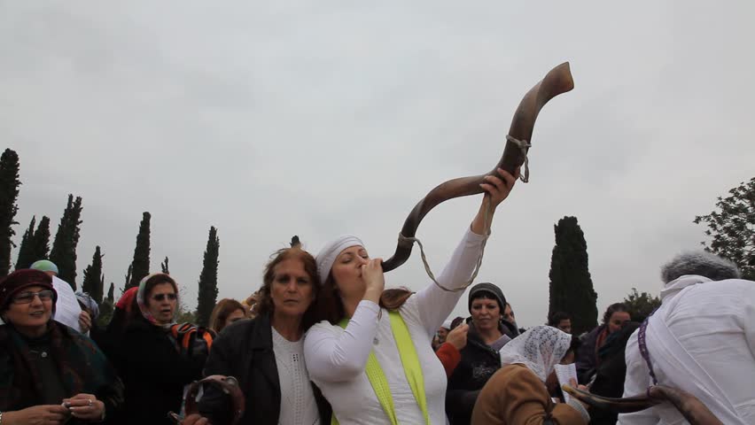 KIRYAT ATTA, ISRAEL - DEC 9, 2009: Jewish woman blows into long horn towards the sky on December 9, 2009 in Kiryat Atta.