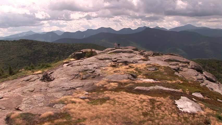 Family walks across summit towards camera