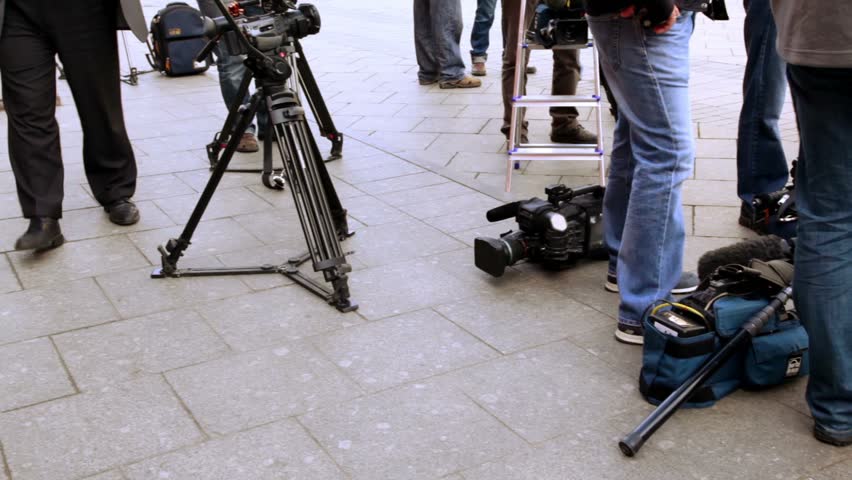 Television equipment lay on ground near operators legs, shown in motion
