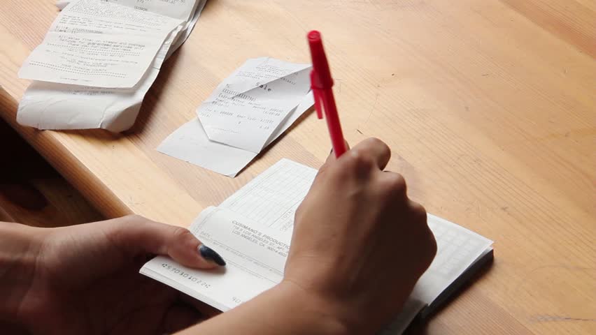Woman opens checkbook and writes check