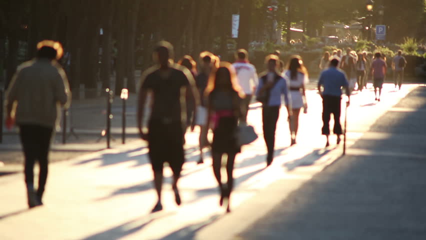 Tourists walk down the Champs Elysees with late afternoon sun