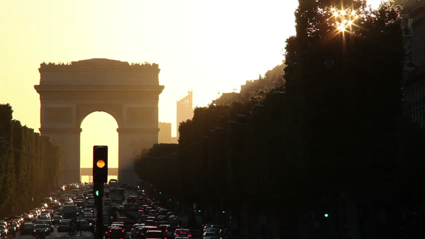 Looking down the bustling Champs Elysees to the Arc de Triomphe with late afternoon sun