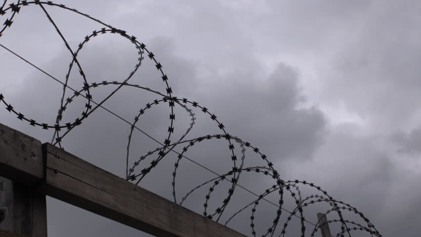 Timelapse of stormy sky over barbed wire