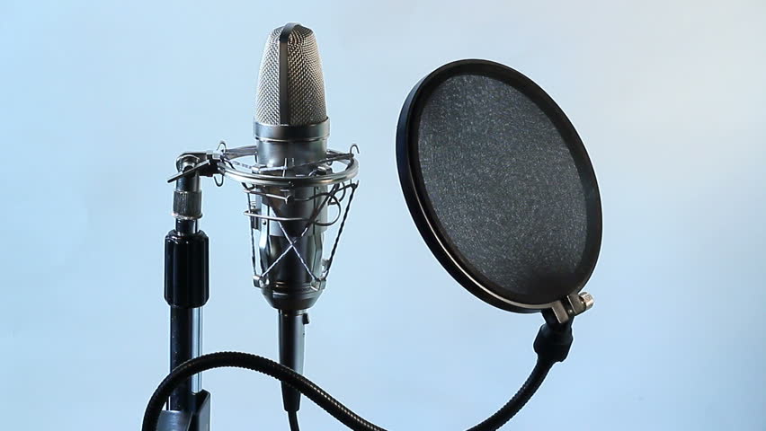 A closeup view of a vocal condenser mic and wind screen.
