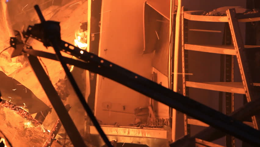 House interior destroyed by intense fire. Flames, smoke and sparks engulfing the interior of a home.