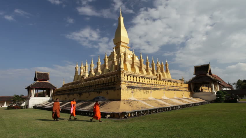 VIENTIANE - OCTOBER 31: Three monks walk in front of the golden pagoda of Vientiane, Capital of Laos on October 31, 2011.