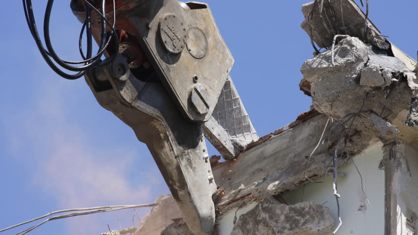 a crane breaking down a building, looking a bit like like a dinosaur eating!