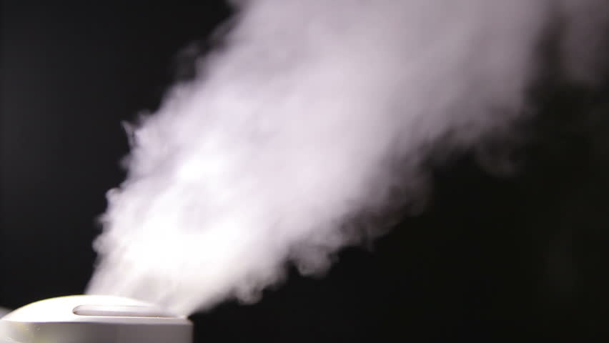 Humidifier emits smoky vapors in dark room at night.