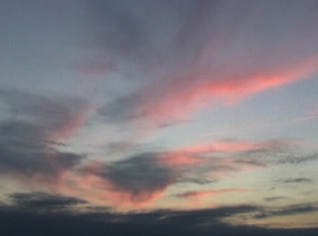 The sun sets and creates beautiful colors in the clouds.