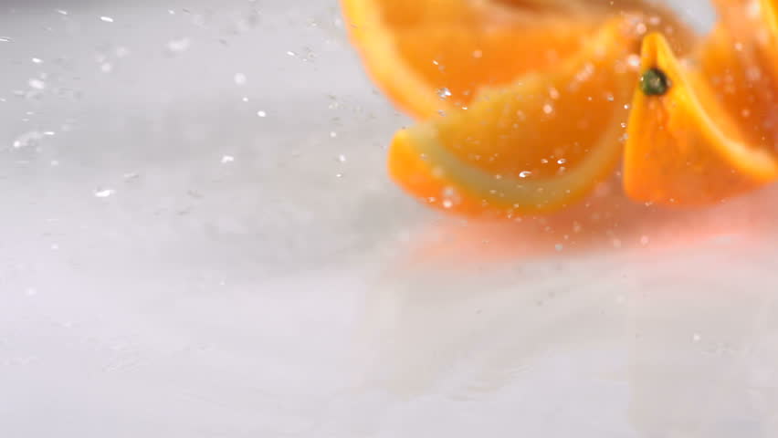 Slo-motion orange falling into wedges