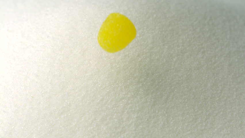 Jelly drops fall atop sugar mound