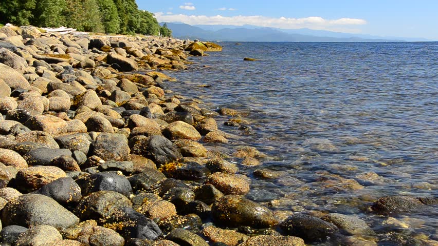 Beautiful stone seashore at sunny day at west coast of pacific ocean in Vancouver, Canada.