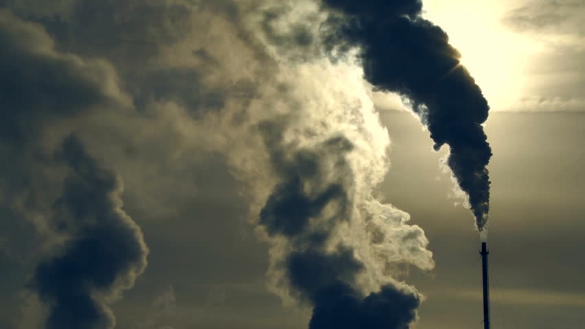 Smokestack of a gas processing refinery with sun