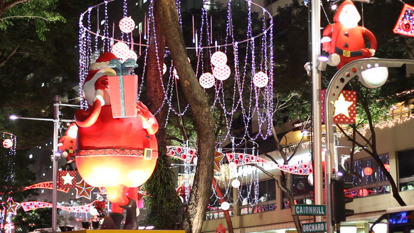 SINGAPORE - NOVEMBER 16: A Santa Claus figure rotates in front of Christmas decor at night on Orchard Road, Singapore on November 16, 2009. Orchard Road is famous for its lavish Christmas light-up.