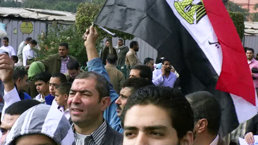 CAIRO, EGYPT - NOV 19: Muslim protesters in Tahrir Square chant slogans as one shows a copy of the koran to the camera on November 19, 2011 in Cairo. 