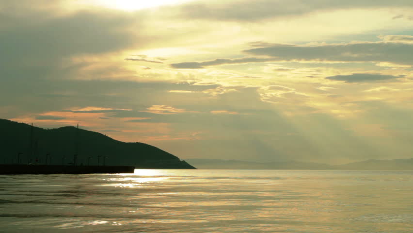 Beautiful sunset with waving sea and sunrays