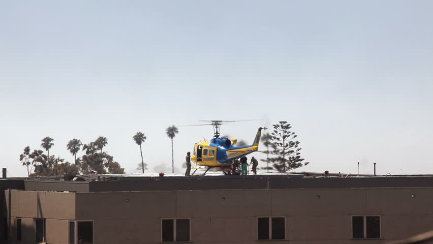Patient being taken off rescue helicopter on the rooftop of a hospital. No recognizable faces or trademarks.