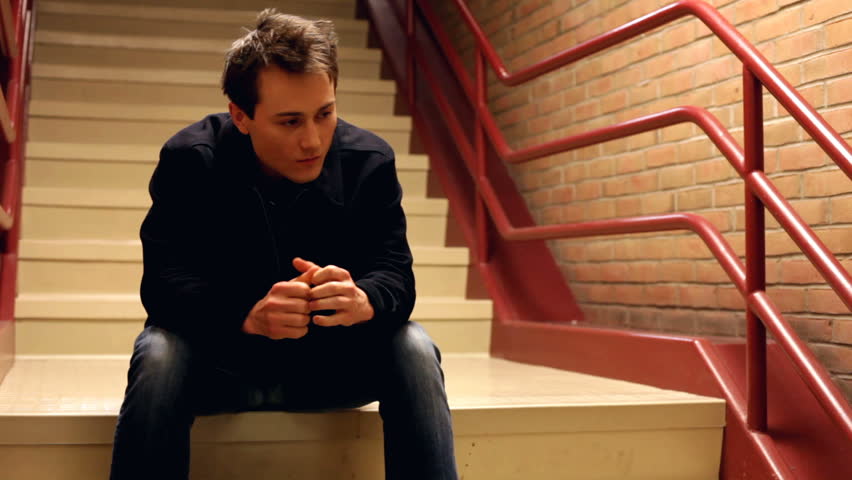 Upset man thinking while sitting on steps